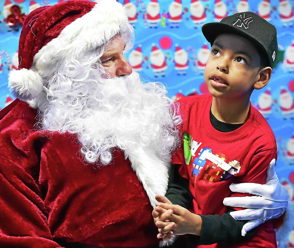 (Catherine Avalone - New Haven Register) Javonnie Rodriguez, 7, of West Haven sits on the lap of a "sensitive" Santa who meets with children on the autisim spectrum one on one in a low-stimuli setting at a holiday party, Saturday, December 19, 2015, at ASD Fitness at 307 Racebrook Road in Orange.