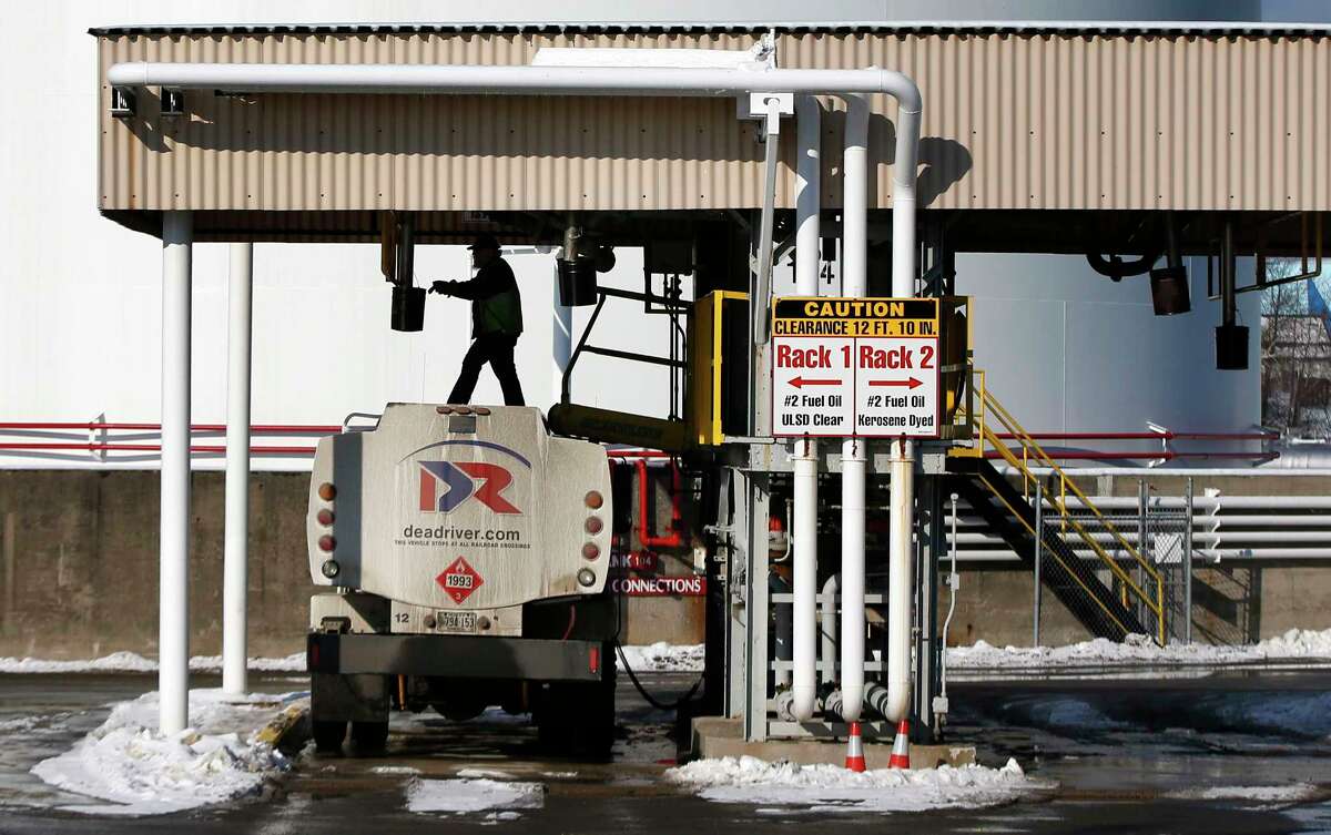 In this Jan. 16, 2015 photo, a driver for an oil delivery company fills his truck at the Sprague terminal in South Portland, Maine. New England is getting another break on heating oil prices this winter, with potential savings of hundreds of dollars per customer, providing breathing room for a region with some of the nation’s highest energy costs. But some officials worry lower prices will lead to complacency on efforts to improve efficiency.