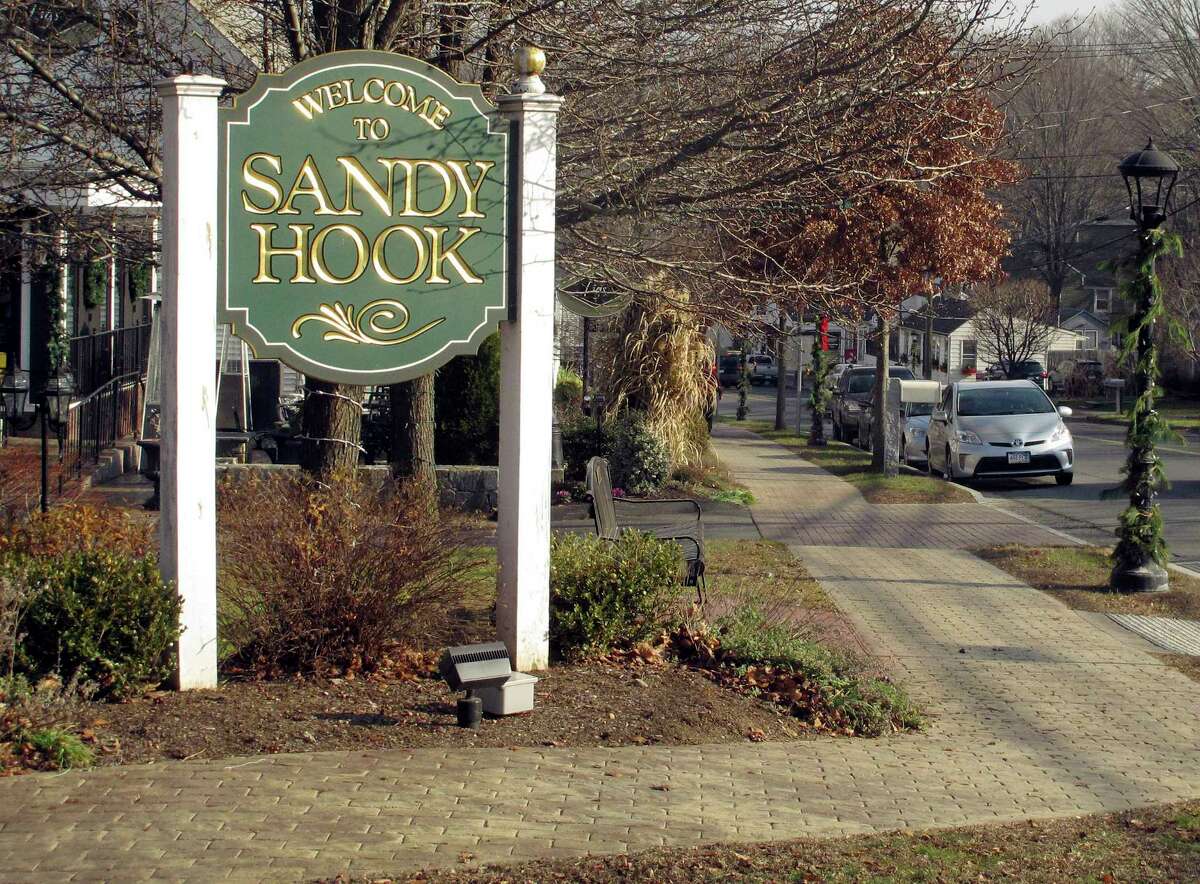 In this Dec. 11, 2015 photo, a sign welcomes people to the village of Sandy Hook in Newtown, Conn. An interfaith service is planned Monday evening, Dec. 14, on the third anniversary of the shooting at Sandy Hook Elementary School that killed 20 first-graders and six educators. Monday is also the first time the anniversary falls on a school day.