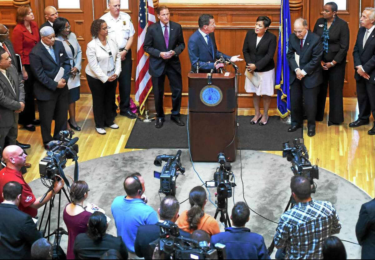 Gov. Dannel P. Malloy, at lectern, gestures to New Haven Mayor Toni Harp during a joint press conference at New Haven City Hall Wednesday announcing the city will receive a $1 million grant for its Fresh Start Re-entry Initiative.