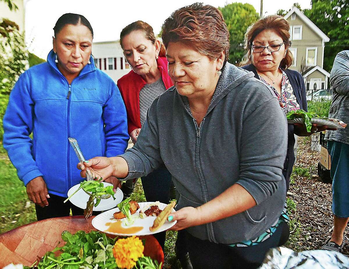 The salad appears a popular choice as Giorgina Castelan, Ladie Orellana and Maria Ocotecatl wait in line for Gloria Gerrano to fill her plate with fresh greens as 22 families celebrate a successful inaugural harvest at the English Street Community Garden in New Haven, Wednesday, October 7, 2015. The women attended classes throughout the summer taught by Jacqueline Maisonpierre, the farm manager for New Haven Farms.