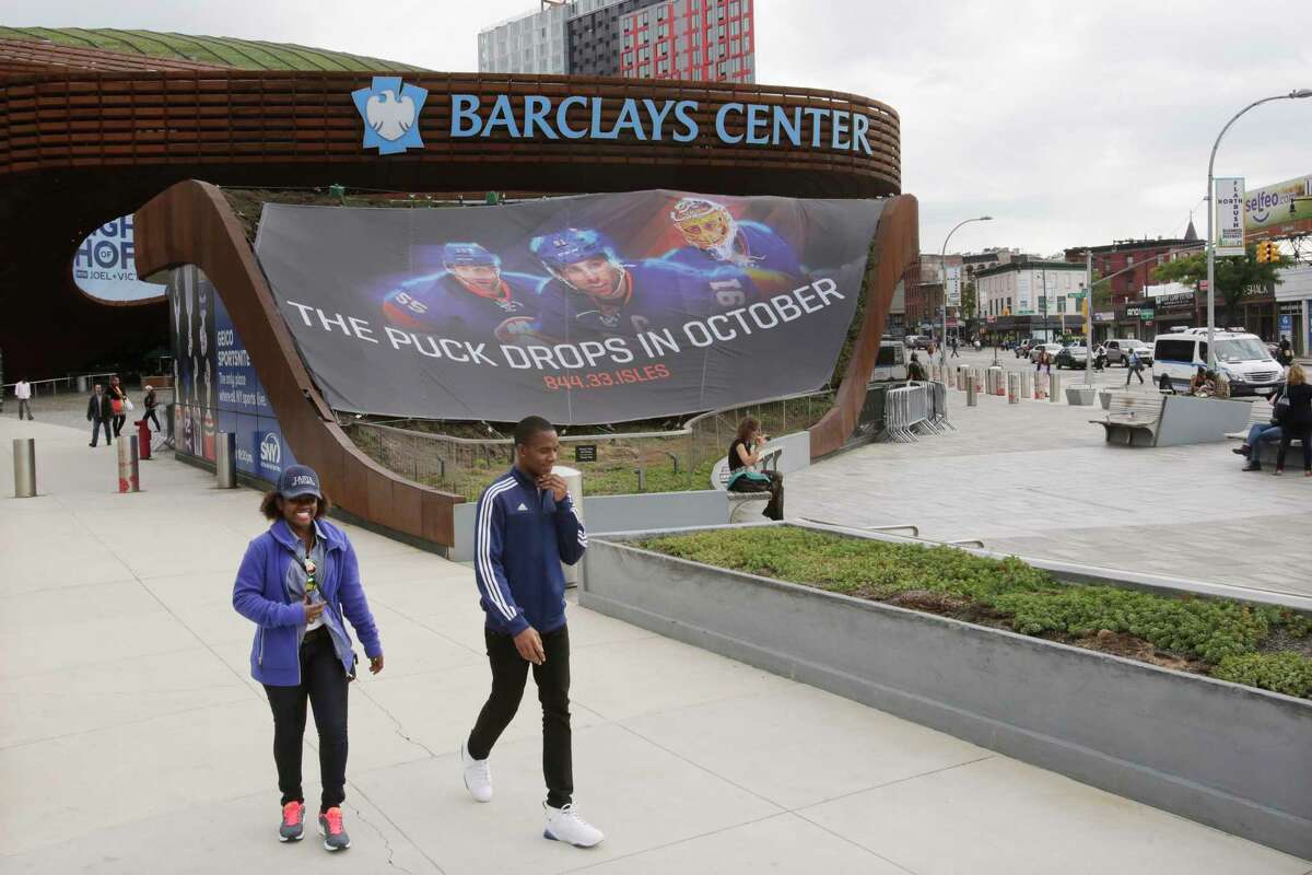 People walk by the Barclays Center on Thursday in Brooklyn. The New York Islanders, who formerly played at Nassau Coliseum in Uniondale, will now call Brooklyn home when they open the 2015-2016 season.