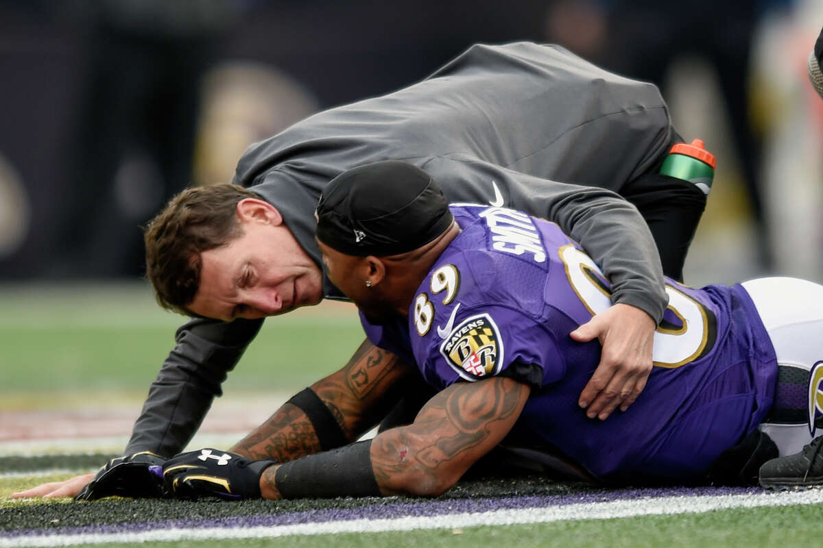 A trainer tends to Ravens receiver Steve Smith after an injury Sunday against the San Diego Chargers in Baltimore.