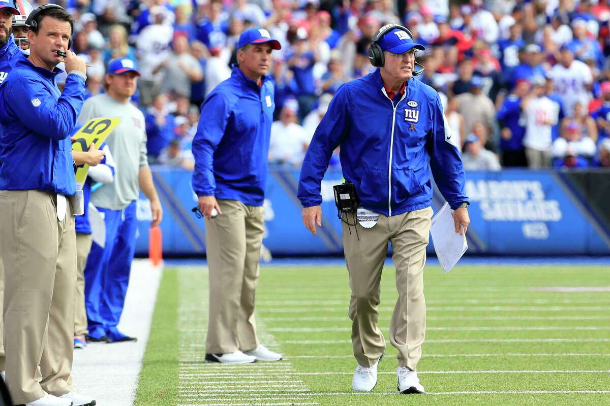 New York Giants head coach Tom Coughlin, right, walks on the field during Sunday’s win over the Bills.