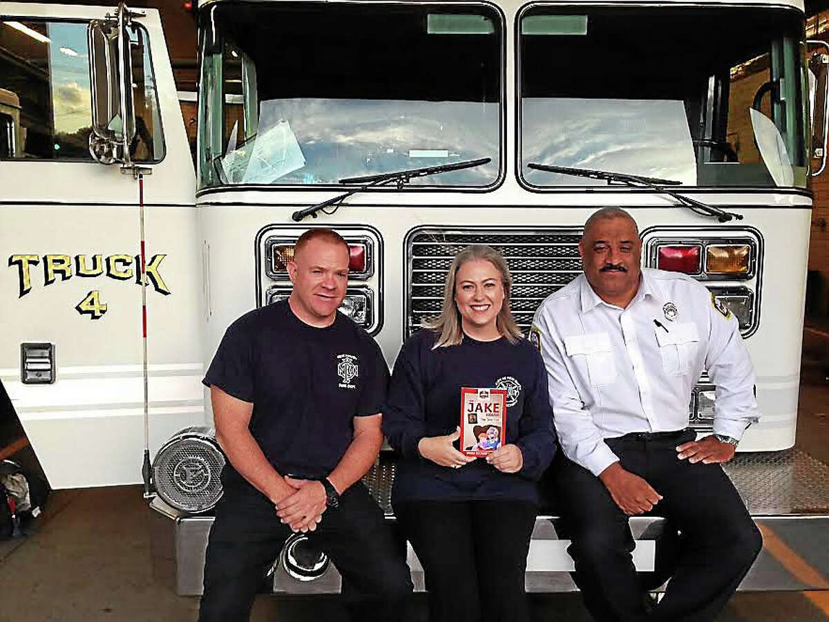 Brigid Buchheit Carney (center), Timothy Carney (left), and Captain Gary Tinney at Dixwell Fire Station.