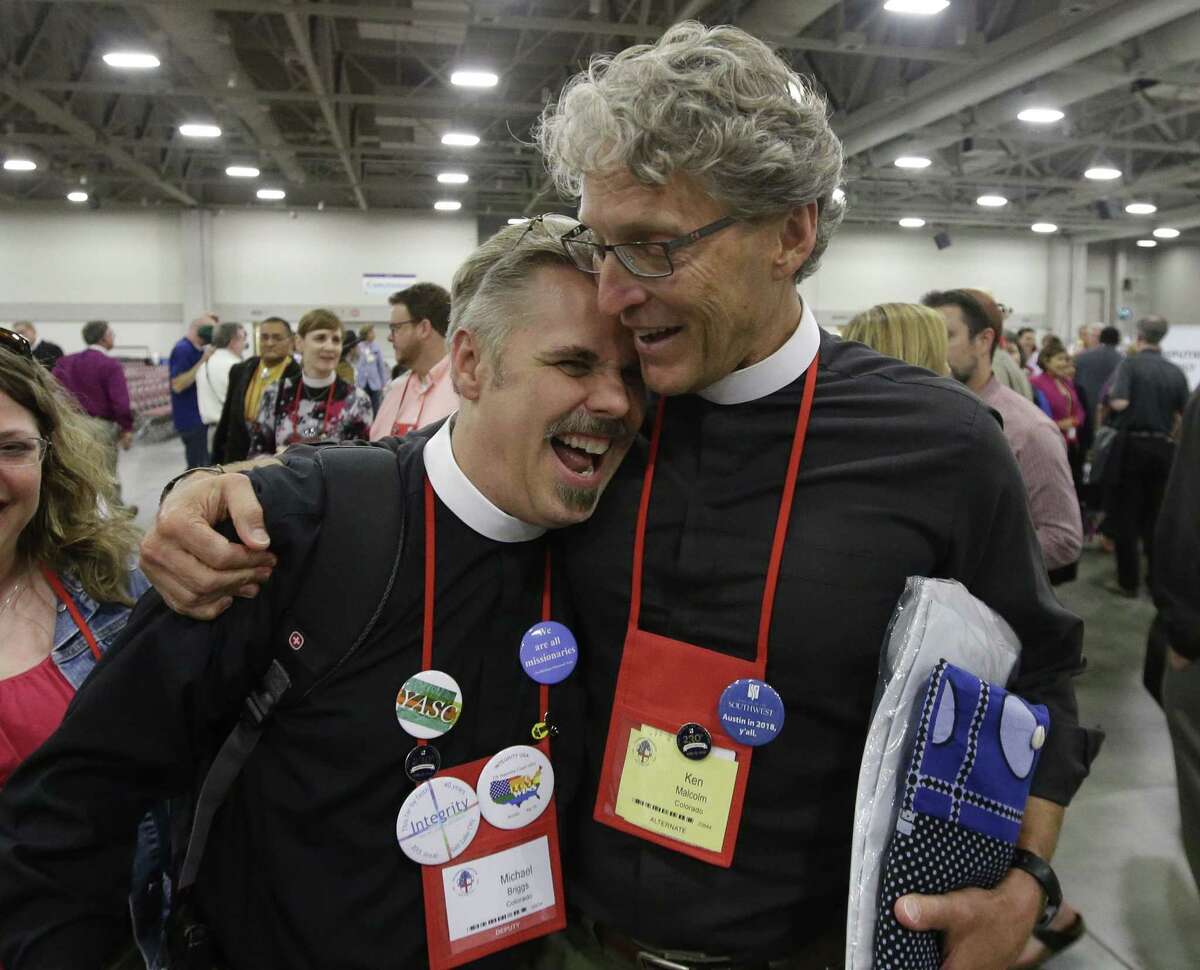 The Rev. Michael Briggs, left, and the Rev. Ken Malcolm, right, hug as they walk after Episcopalians overwhelmingly voted to allow religious weddings for same-sex couples Wednesday, July 1, 2015, in Salt Lake City. The vote came in Salt Lake City at the Episcopal General Convention, just days after the U.S. Supreme Court legalized gay marriage nationwide. (AP Photo/Rick Bowmer)