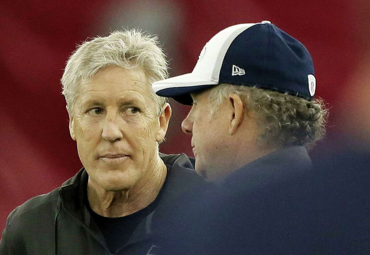 Seattle Seahawks head coach Pete Carroll, left, talks with quarterbacks coach Carl Smith during Friday’s practice in Tempe, Ariz.