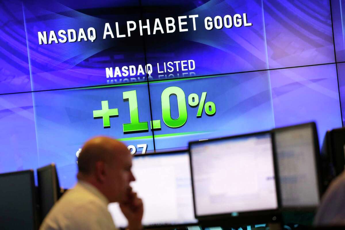 FILE - In this Monday, Feb. 1, 2016, file photo, electronic screens post the price of Alphabet stock at the Nasdaq MarketSite in New York. Google parent Alphabet is taking a $2.7 billion write-down to cover a large fine EU antitrust enforcers assessed in June 2017. While the search giant can shrug off the cost, uncertainty lingers over its ability to operate freely on the continent going forward. (AP Photo/Mark Lennihan, File)