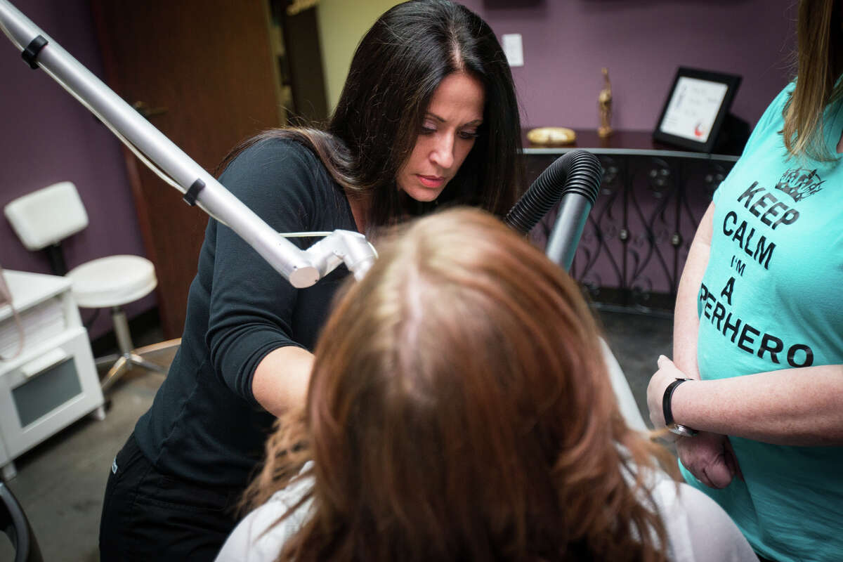 Phoenix Charity founder Tracie Mann performs a tattoo removal procedure on a human trafficking victim Monday, July 24, 2017, at Body Restore Med Spa and Laser Center in The Woodlands.