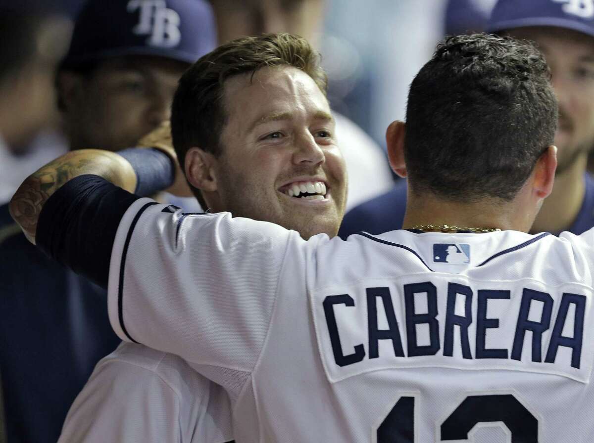 Tampa Bay Rays’ Jake Elmore, left, gets a hug from Asdrubal Cabrera in the dugout after Elmore hit a home run off Boston Red Sox relief pitcher Edward Mujica during the seventh inning Wednesday.