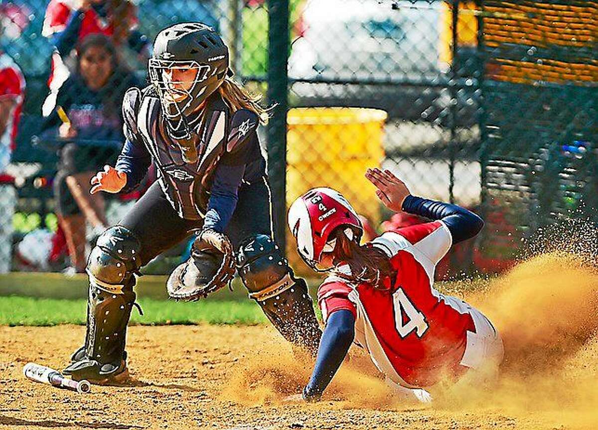 Amity catcher Teresa Marchitto is empty handed as Foran’s Natalia Hart slides safely into home Wednesday in Woodbridge. The Foran Lions defeated the Spartans, 6-4.