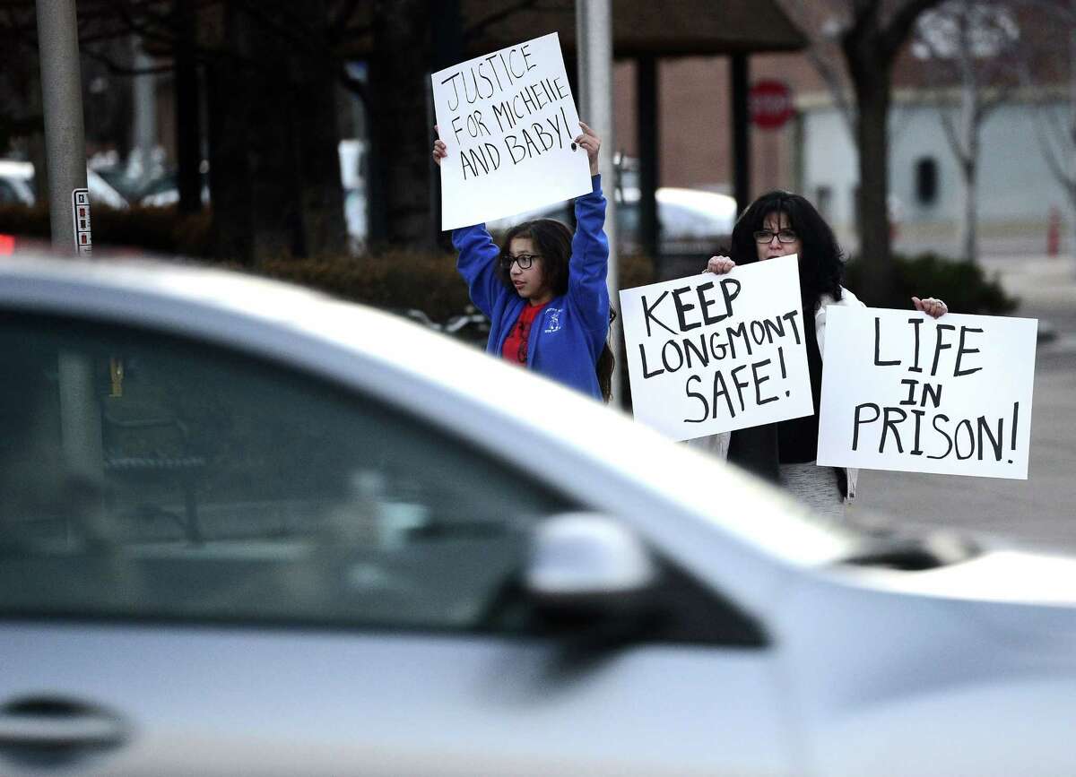 Eileen Egger, right, holds a sign with her granddaughter Naomi Garcia, 11, while cars pass by during a protest against Dynel Lane on Thursday, March 19, 2015, in Longmont, Colo. Lane is accused of stabbing a pregnant woman in the stomach and removing her baby, while the expectant mother visited her home to buy baby clothes advertised on Craigslist authorities said. The baby did not survive. (AP Photo/The Daily Camera, Jeremy Papasso) NO SALES