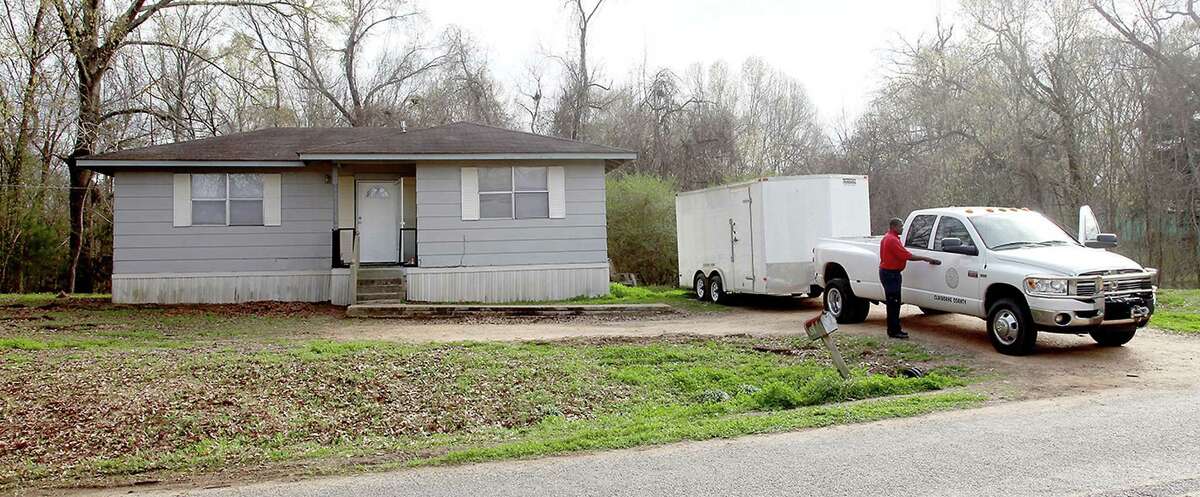 Claiborne County officials prepare to leave a home in Port Gibson, Miss., where authorities were investigating the hanging death of a black man in the neighboring woods, Thursday, March 19, 2015. The man has not been identified.