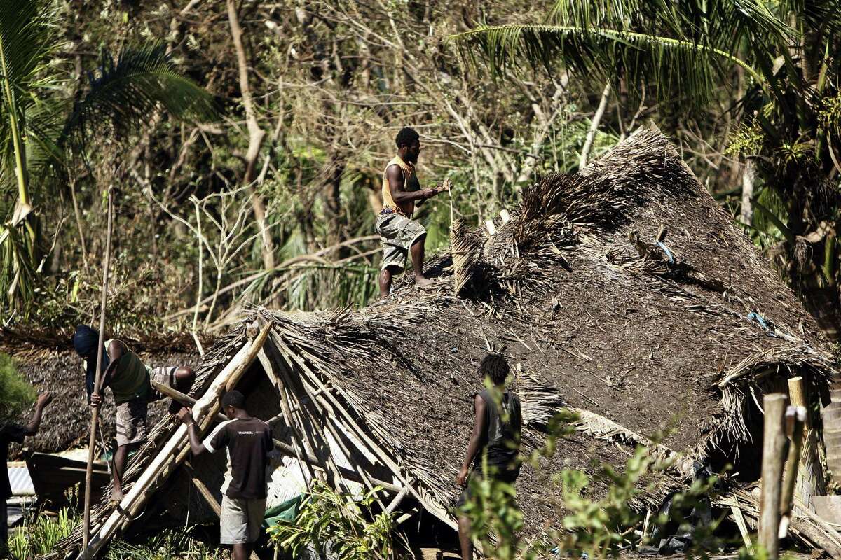 Young men take apart a hut destroyed by Cyclone Pam, Thursday, March 19, 2015, on Tanna Island, Vanuatu. Tanna Island in the southern part of the Vanuatu archipelago was one of the hardest hit when Cyclone Pam tore through the South Pacific nation early Saturday. The cyclone's 270 kilometer (168 mile) per hour winds pummeled lush tropical forests on Tanna into a brown jumble of broken trunks and strewn branches. (AP Photo/Nick Perry)