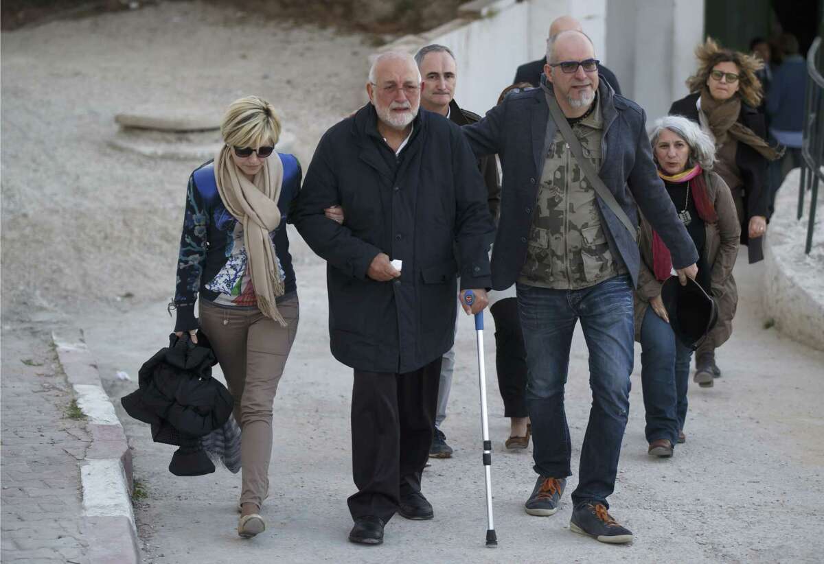 A unidentified Italian relative of a victim of the Tunis museum attack, center, is helped by Italian embassy staff , as he leaves the morgue of the Charles Nicolle hospital in Tunis Tunisia, Thursday, March 19, 2015. The radical Islamic State Group claimed responsibility Thursday for the attack on a famed Tunis museum that left 23 people dead. (AP Photo/Michel Euler)