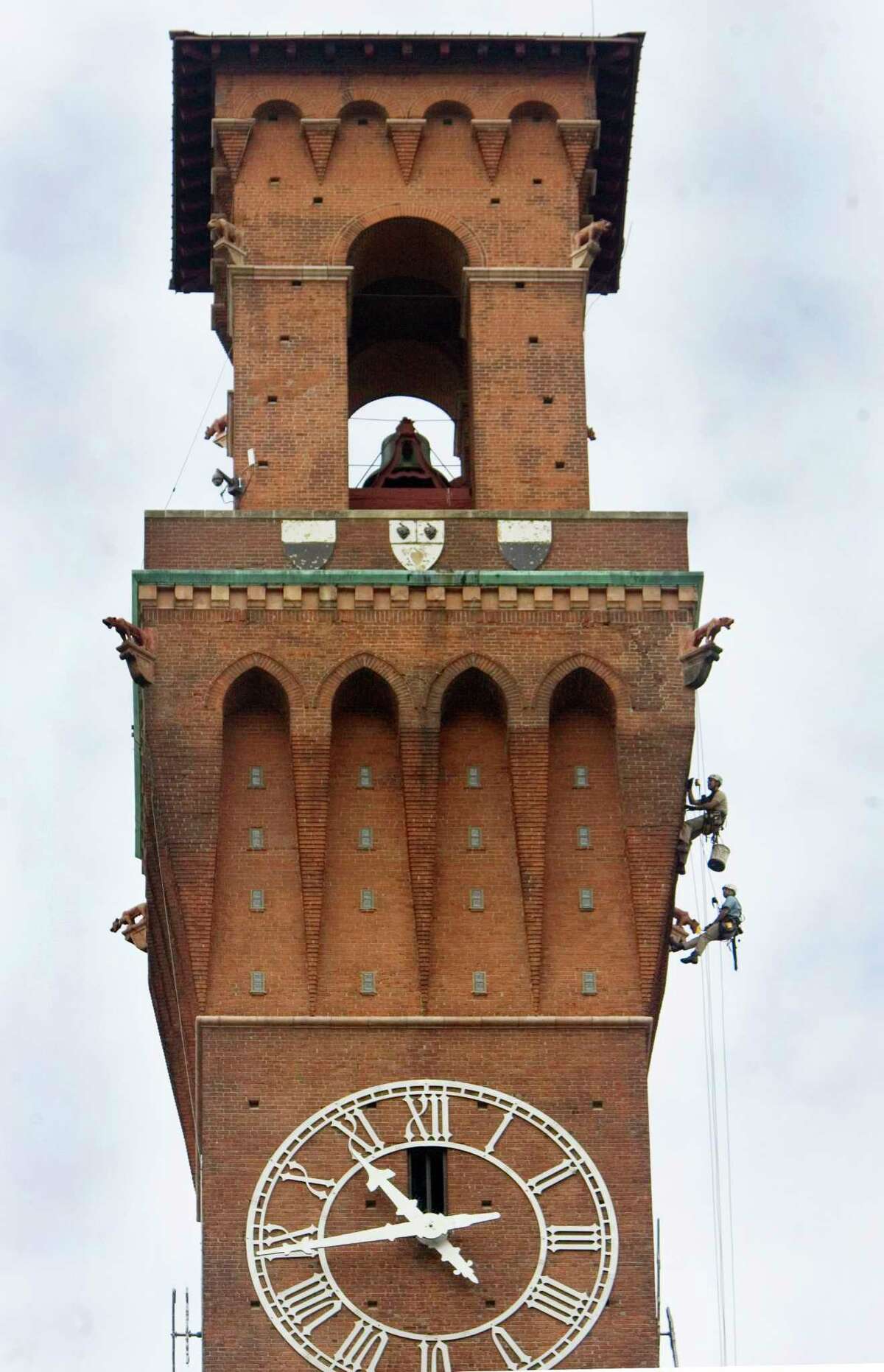 Workers descend down the Republican-American's clock tower to investigate the condition of each face of the 240-foot-tall structure in Waterbury, Conn. Thursday June 18th 2015. The results of their inspection will be used to design repairs to the 109-year-old clock tower. (Steven Valenti/The Republican-American via AP) MANDATORY CREDIT