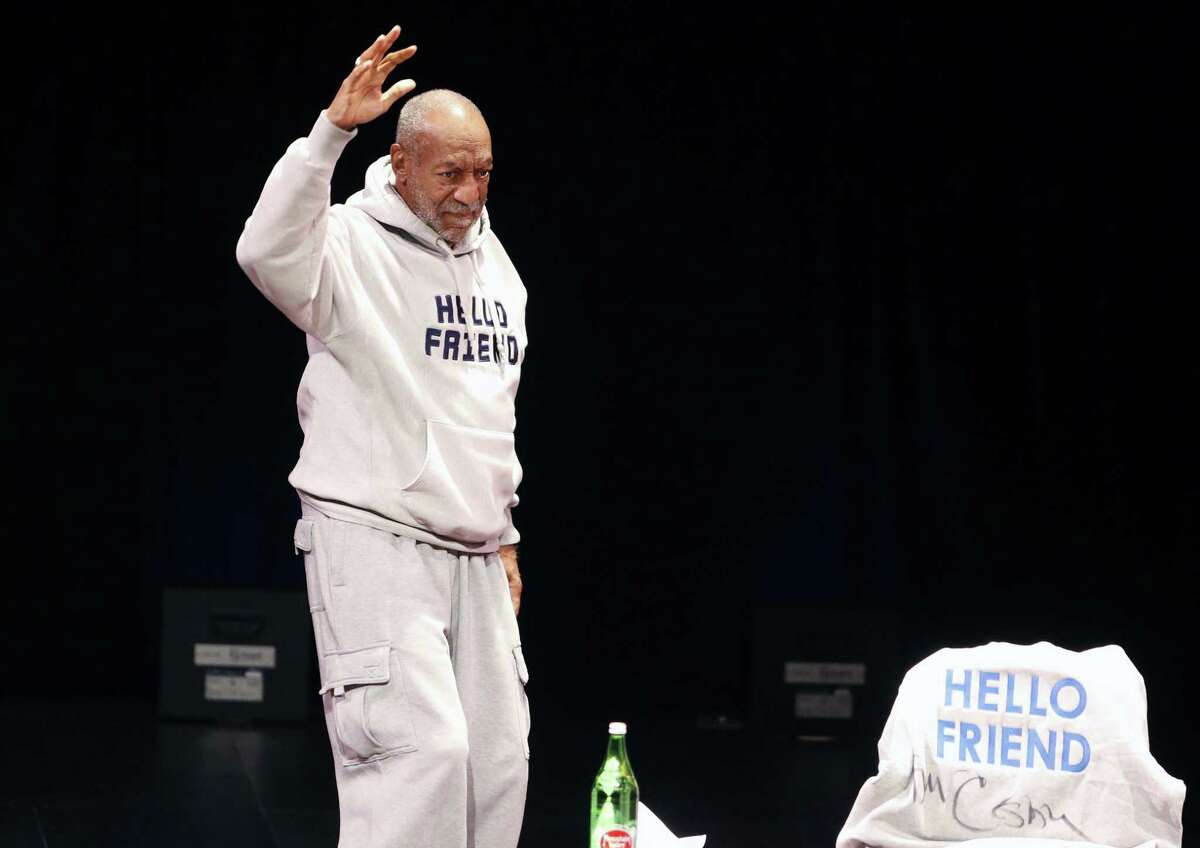 Comedian Bill Cosby waves as he walks onstage for a performance at the Buell Theater in Denver on Jan. 17, 2015.