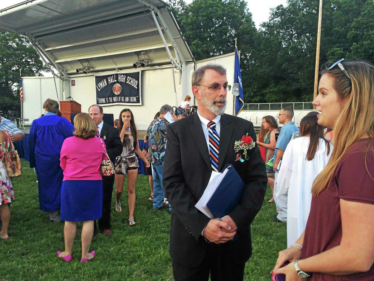 Retiring Lyman Hall Principal David Bryant chats with a well wisher after having presided over his last graduation ceremony Friday.