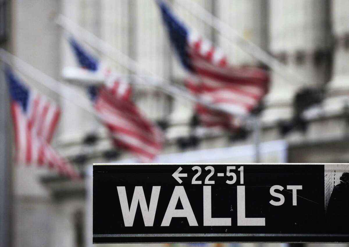 FILE - This April 22, 2010, file photo, shows a Wall Street sign in front of the New York Stock Exchange. Asian shares pushed higher Friday, June 19, 2015, following a rally in U.S. markets, but China’s benchmark sank again on worries over the potential impact of a flurry of initial public offerings and moves by regulators to curb margin trading.