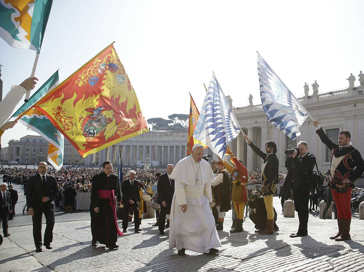 Pope Francis, center, walks past faithful wearing traditional costumes and holding flags as he arrives for his weekly general audience in St. Peter's Square, at the Vatican, Wednesday, March. 18, 2015. (AP Photo/Gregorio Borgia)