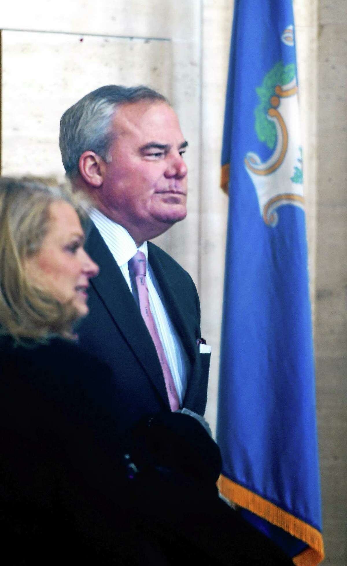 Former Connecticut Governor John Rowland, center, waits inside the lobby of Federal Court in New Haven before sentencing with his wife, Patty, left, Wednesday.
