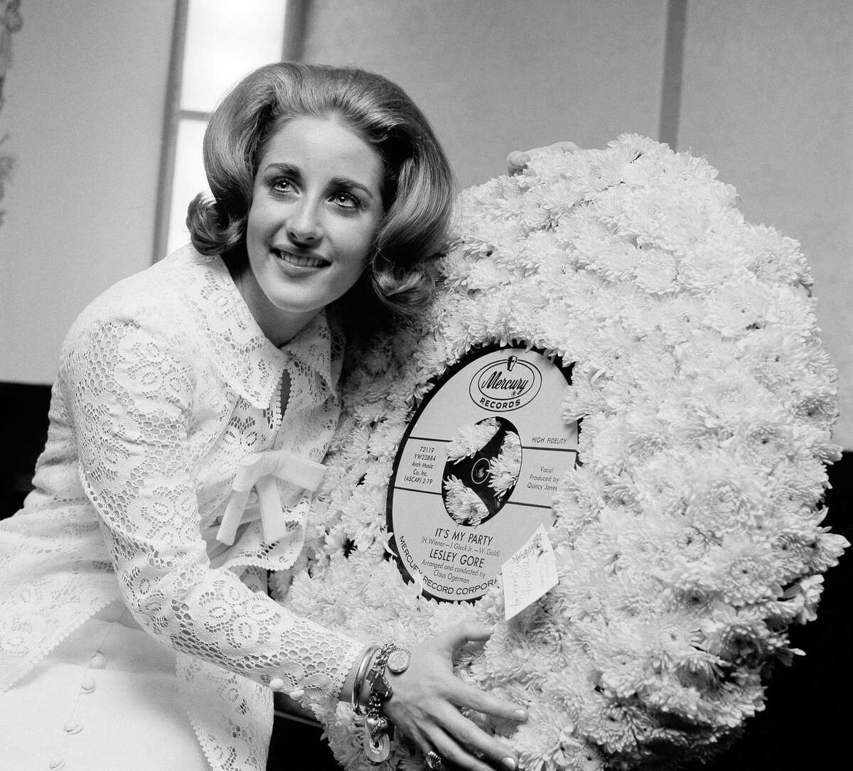 In this May 5, 1964 file photo, singer Lesley Gore hugs a flowered record at her 18th birthday party celebrated at the Delmonico Hotel in New York.