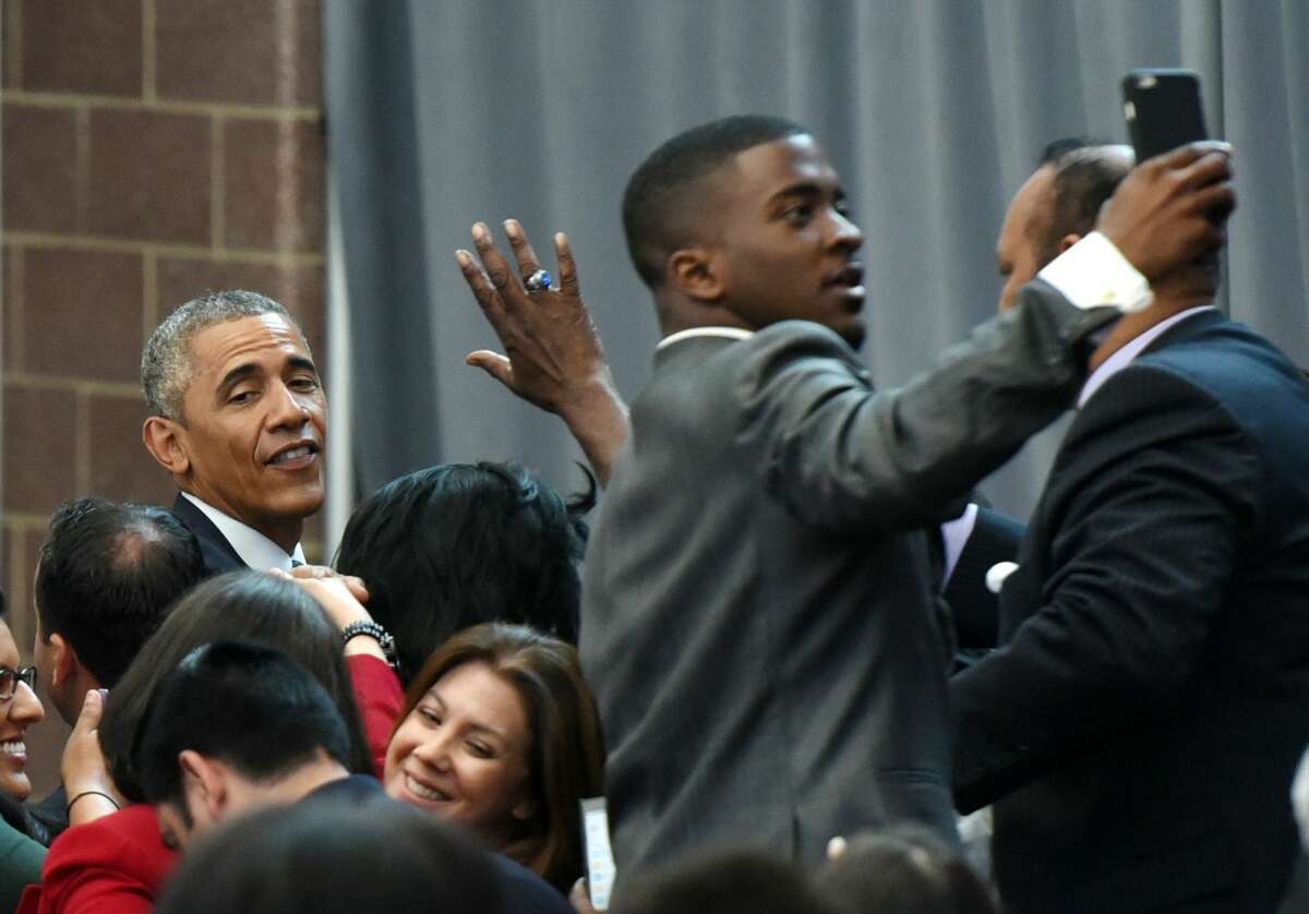 A young man elevates above the crowd trying to take a selfie with President Obama at Ray and Joan Kroc Corps Community Center during his visit to Camden, N.J. on Monday, May 18, 2015. Obama also visited with local law enforcement and youth in the community. On Monday, President Obama also banned the federal government from providing some military-style equipment to local police departments and put much stricter controls on others.