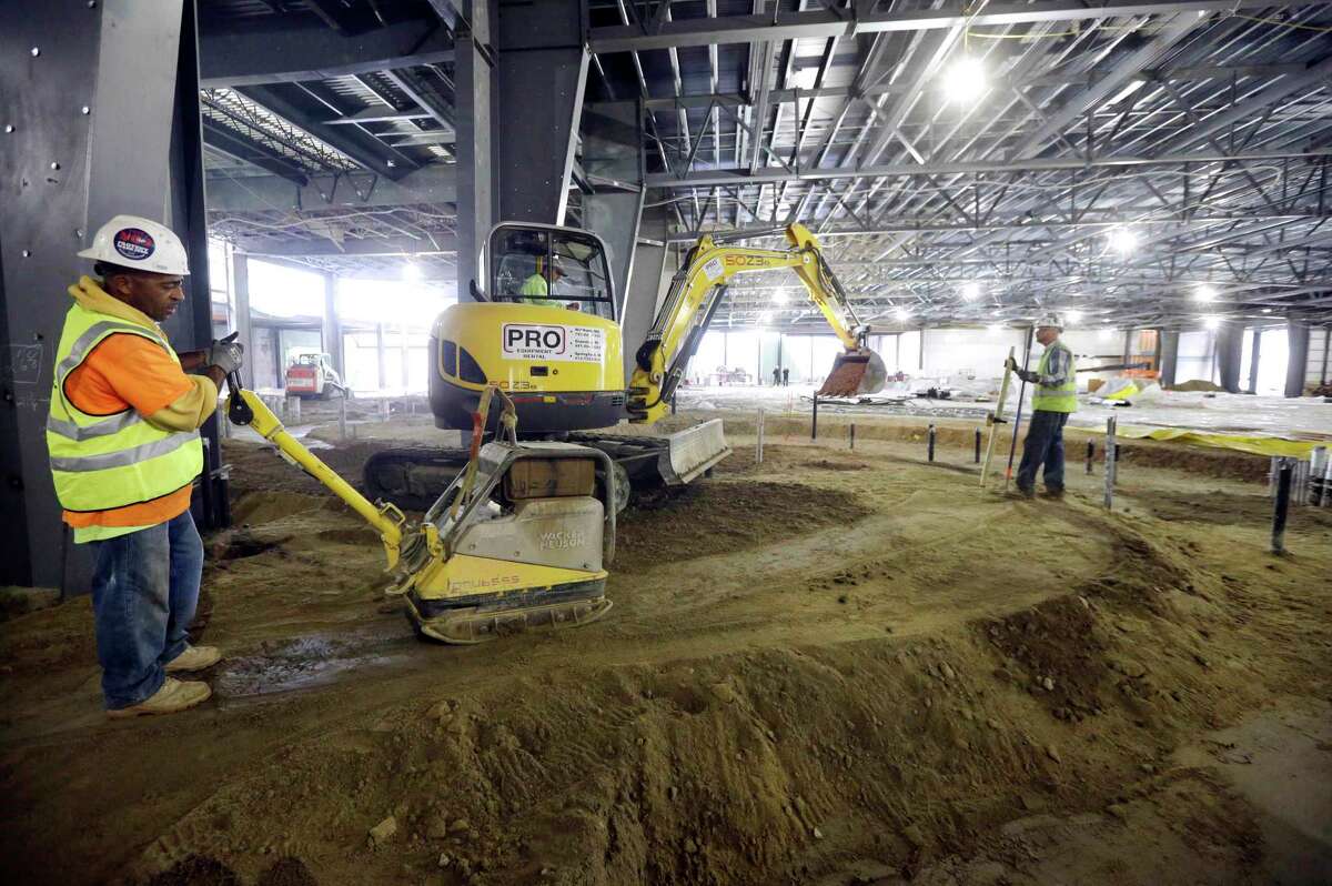 In this Oct. 1, 2014 photo, workers prepare an area for concrete in the planned casino floor of the Plainridge Park Casino, under construction adjacent to the Plainridge Racecourse harness racing track in Plainville, Mass.