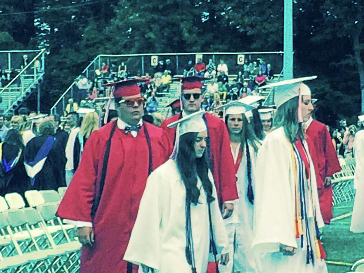 LUTHER TURMELLE — NEW HAVEN REGISTER Some of Cheshire High School’s 389 seniors march into Thursday night’s graduation ceremony at Alumni Field.