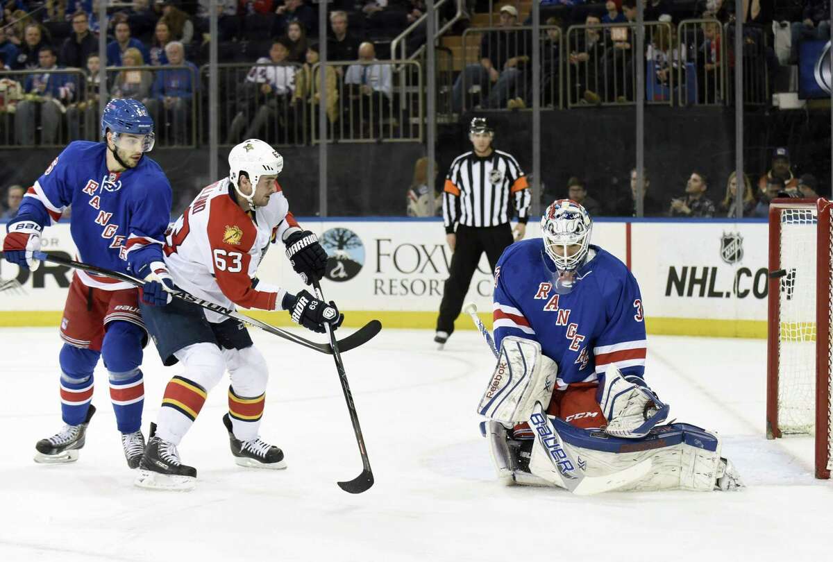 Rangers goalie Cam Talbot, right, deflects a shot by the Florida Panthers’ Dave Bolland (63) as Bolland is checked by Derick Brassard during Sunday’s game at Madison Square Garden in New York.