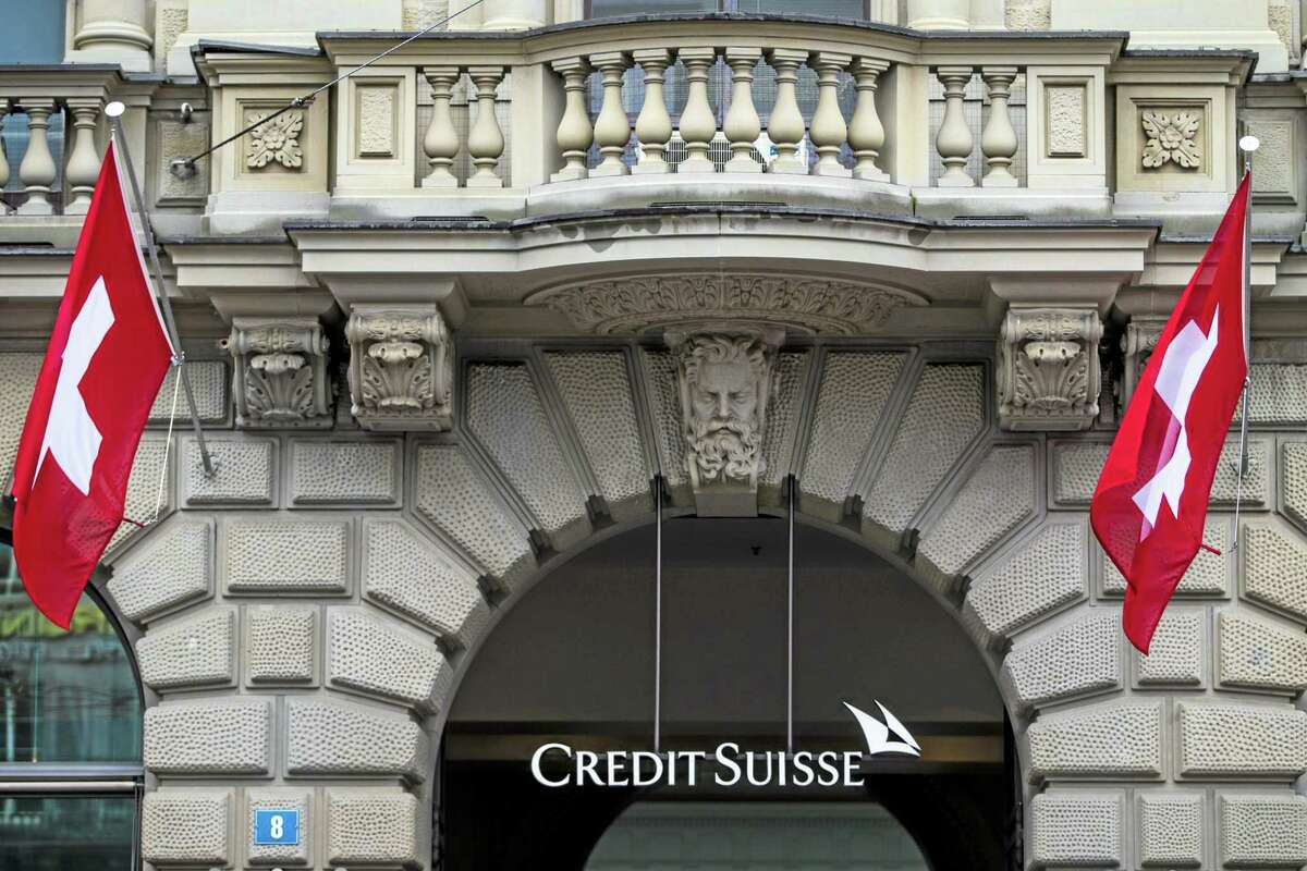In this April 27, 2014, file picture, Swiss flags fly at the entrance of of Swiss bank Credit Suisse in Zurich, Switzerland. European bank Credit Suisse AG pleaded guilty to helping wealthy Americans avoid paying taxes through secret offshore accounts and agreed to pay about $2.6 billion.