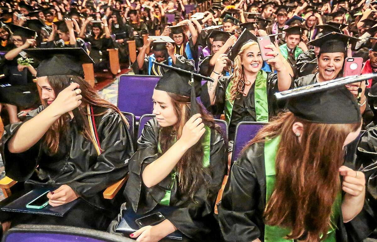 (John Vanacore/for the New Haven Register) Grads adjust their tassles at the University of New Haven 2015 Commencement Ceremony at Toyota Oakdale Theatre in Wallingford Sunday.