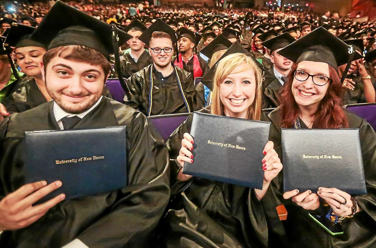 (John Vanacore/for the New Haven Register) Three new grads show off their diplomas at the University of New Haven 2015 Commencement Ceremony at Toyota Oakdale Theatre in Wallingford Sunday.