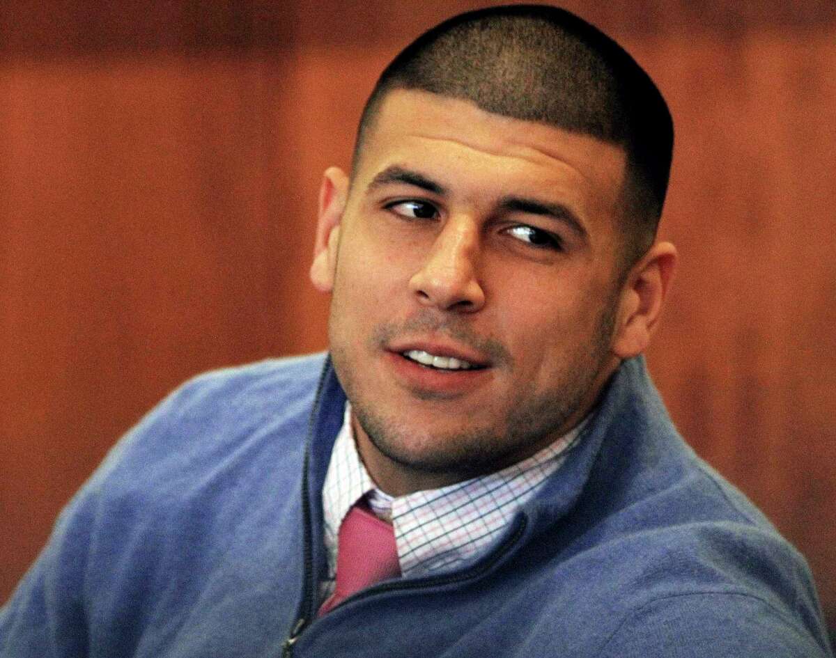 FILE - In this Oct. 1, 2014 file photo, former New England Patriots football player Aaron Hernandez looks back during an evidentiary hearing at Fall River Superior Court in Fall River, Mass. Authorities have returned to the home of ex-New England Patriots player Aaron Hernandez seeking sneakers they believe were worn on the night of a 2013 killing he's charged in. The Sun Chronicle reports state and local authorities went to Hernandez's North Attleborough home this week but seized no evidence. (AP Photo/The Boston Globe, Wendy Maeda, Pool)