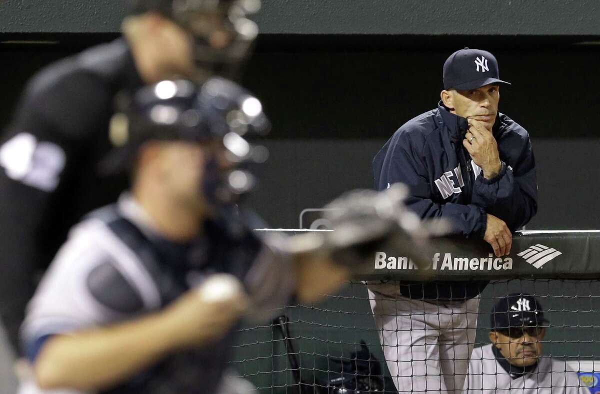 New York Yankees manager Joe Girardi watches Yankees catcher Brian McCann and home plate umpire Sean Barber from the dugout in the sixth inning of Wednesday’s 7-5 loss to the Orioles.