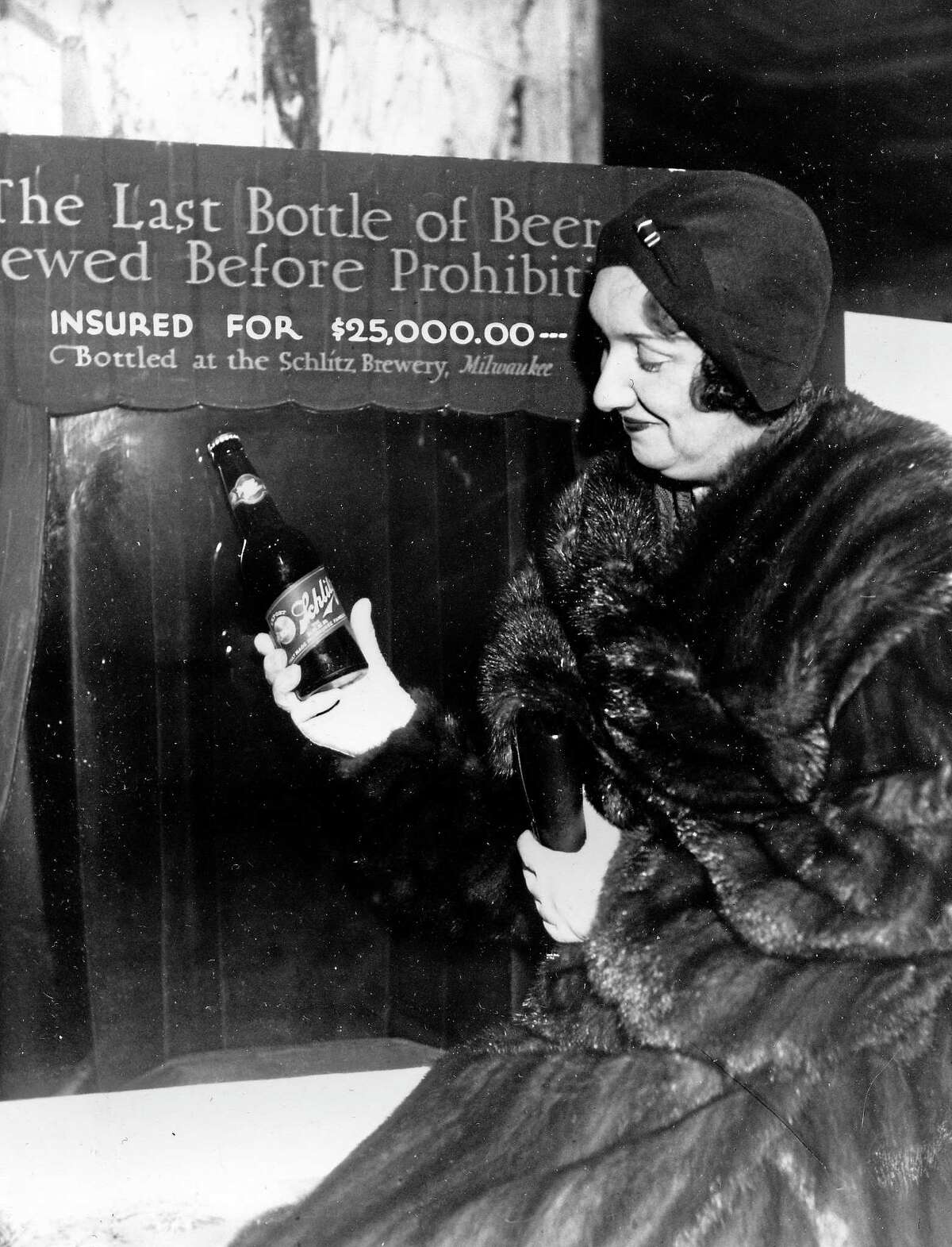 Rae Samuels holds the last bottle of beer that was distilled before prohibition went into effect in Chicago, Ill., Dec. 29, 1930. The bottle of Schlitz has been insured for $25,000. (AP Photo)