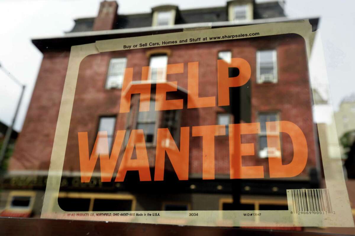 In this file photo, a Philadelphia business displays a help wanted sign in its storefront.