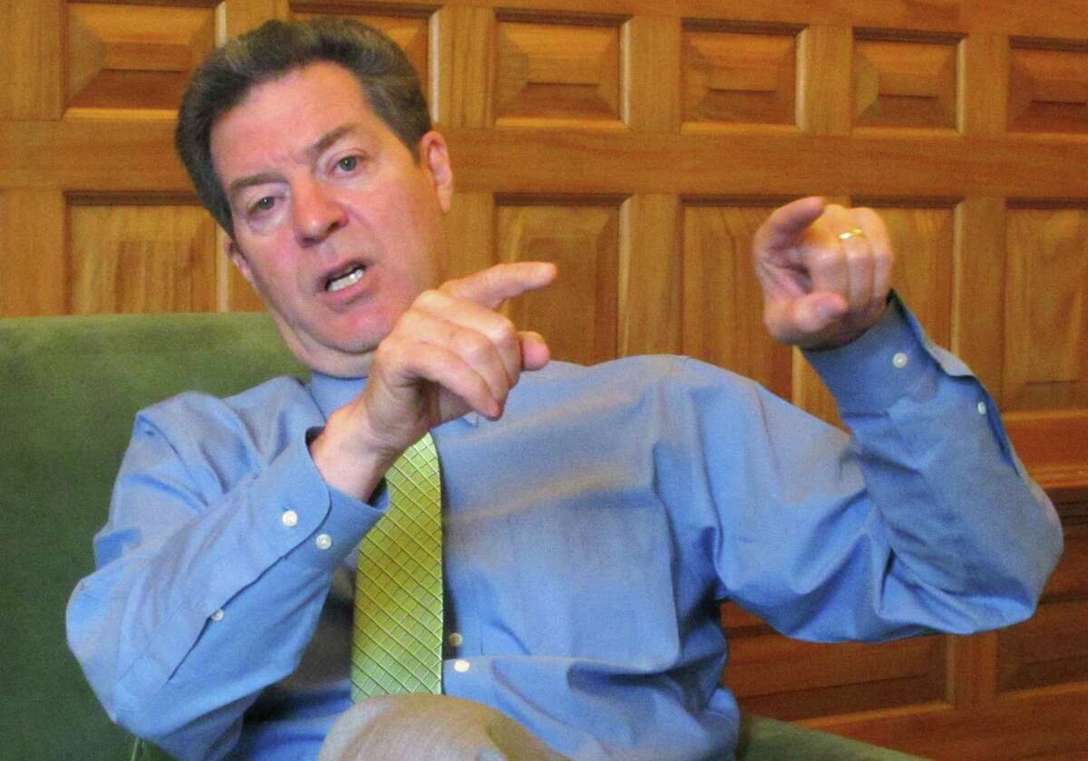 In this April 13, 2015 photo, Kansas Republican Gov. Sam Brownback makes a point during an interview in his office in the Statehouse in Topeka, Kan. Brownback is preparing to sign welfare legislation restricting how poor families can spend cash assistance from the state. The Republican governor scheduled a Thursday, April 16, 2015, morning signing ceremony at the Statehouse. (AP Photo/John Hanna)