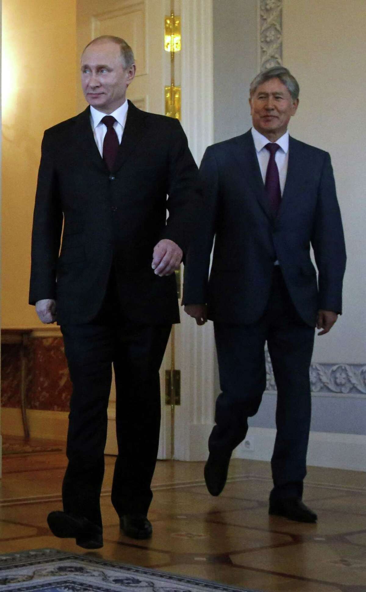 Russian President Vladimir Putin, left, and Kyrgyz President Almazbek Atambayev enter the hall for their meeting in the Konstantin Palace outside St. Petersburg, Russia on March 16, 2015.