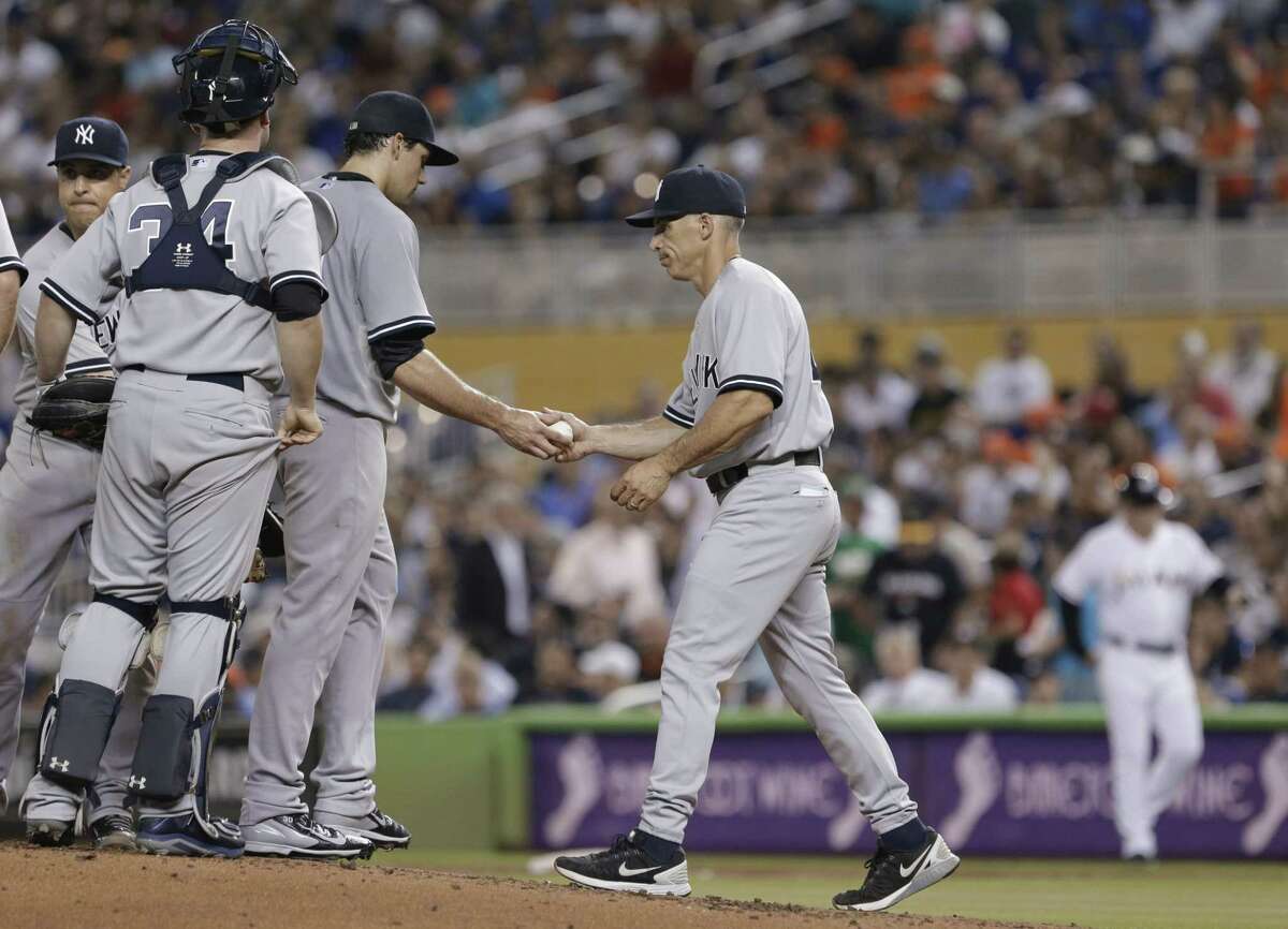 Yankees starting pitcher Nathan Eovaldi is taken out of the game by manager Joe Girardi, right, during the first inning against the Miami Marlins.