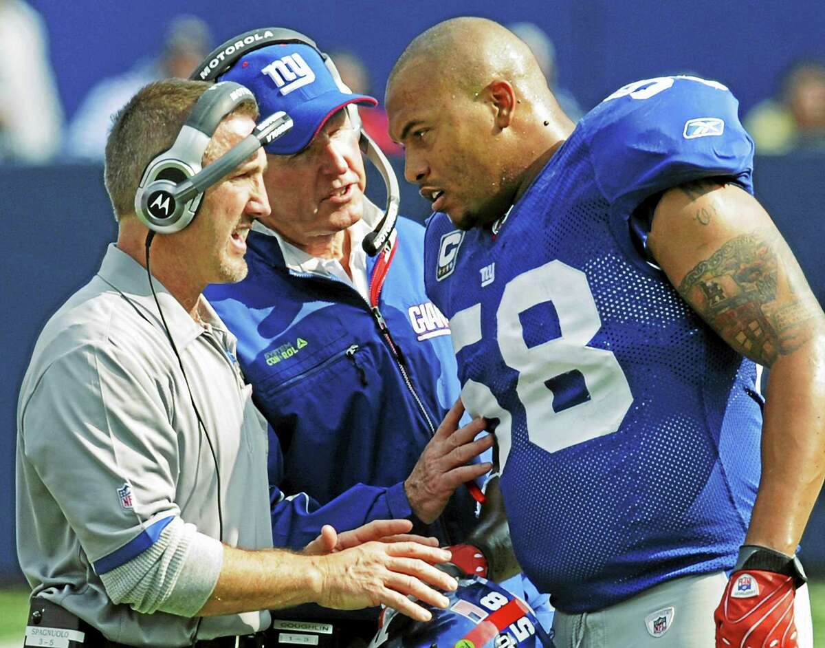 New York Giants defensive coordinator Steve Spagnuolo, left, and coach Tom Coughlin talk with linebacker Antonio Pierce, right, during a 2008 game.