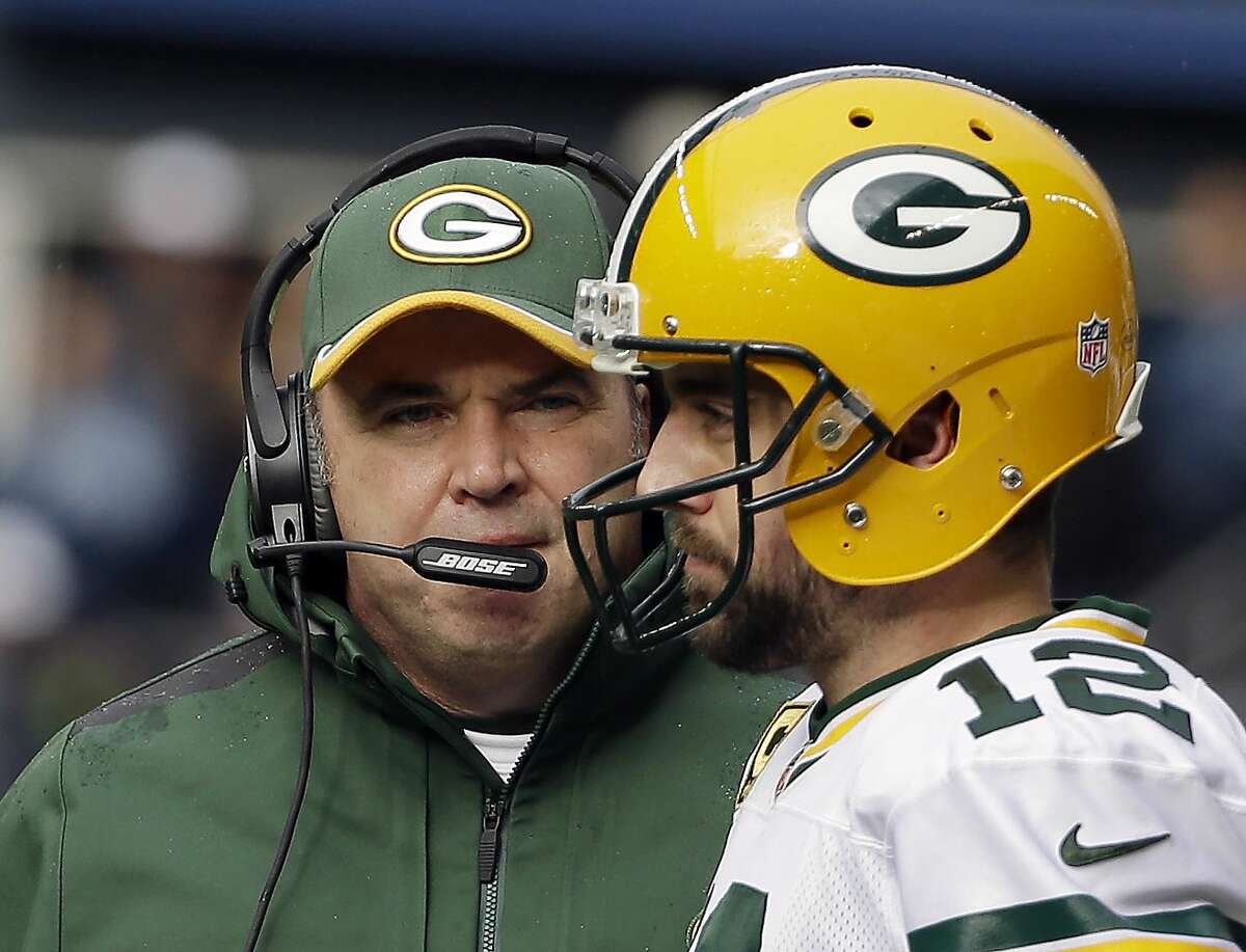 Green Bay Packers' Mike McCarthy holds a team helmet after being