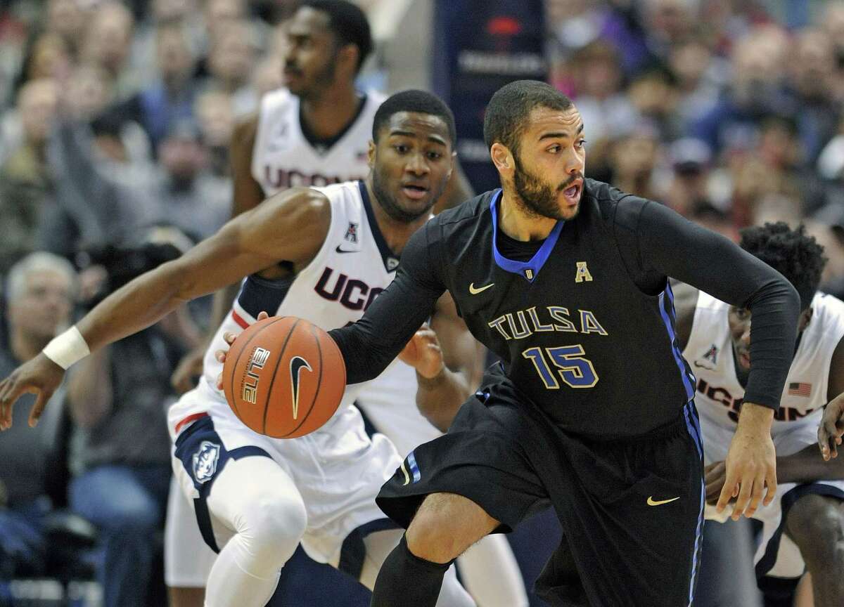 Tulsa’s Marquel Curtis is guarded by UConn’s Rodney Purvis (44) during the first half Thursday.