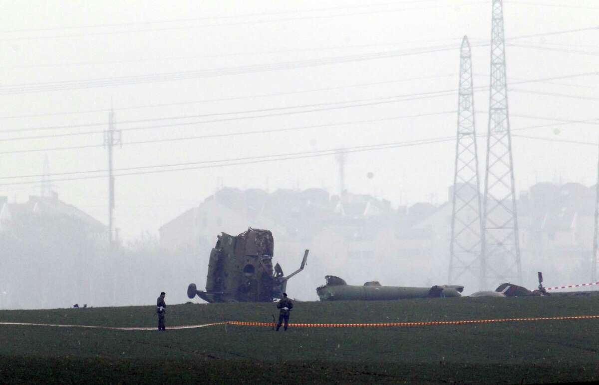Serbian army soldiers guard the site of a helicopter crash on the outskirts of Belgrade, Serbia, Saturday, March 14, 2015. Officials say a Serbian military helicopter has crashed near Belgrade while evacuating a sick baby from south of the country, killing all seven people on board. (AP Photo)
