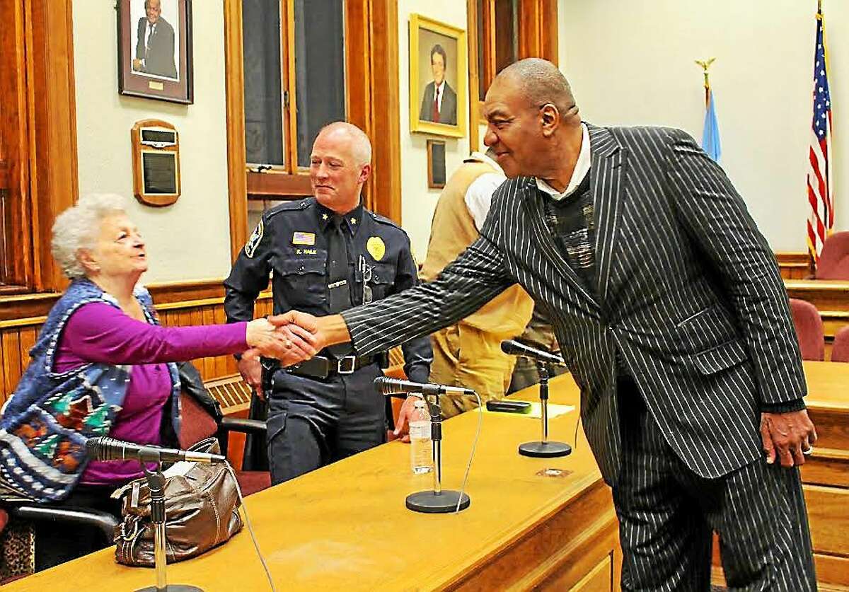 Alderwoman Joan Radin shakes hands with the Rev. Al Smith at Thursday’s community conversation. In the background is Police Chief Kevin Hale.