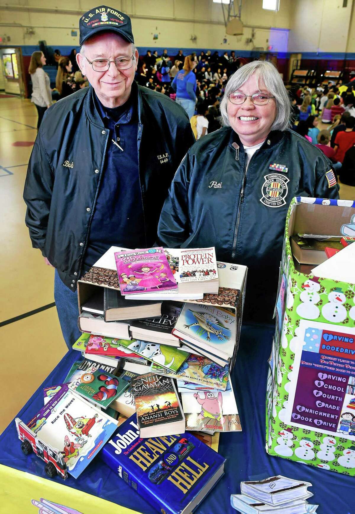 Robert Chechoski, left, of Vietnam Veterans of America Chapter 251 and Patricia Dumin, state council president of the Vietnam Veterans of America, are photographed Wednesday at a book drive coordinated by fourth-graders at Irving School in Derby.
