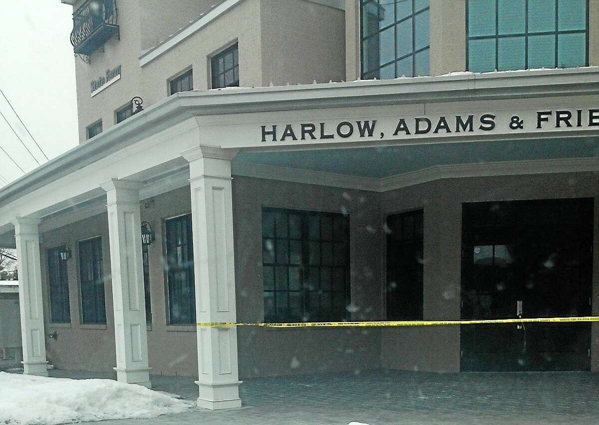 (Pamela McLoughlin -- New Haven Register) Police tape is visible at offices connected to a parking garage where two males were injured in a shooting at 1 New Haven Ave. in Milford on March 1, 2015.