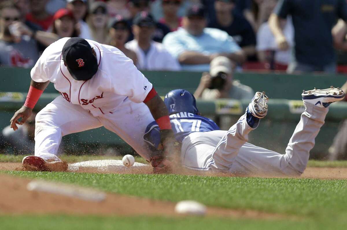 Pablo Sandoval, left, is unable to tag the Blue Jays’ Ryan Goins, right, in the seventh inning Sunday at Fenway Park.