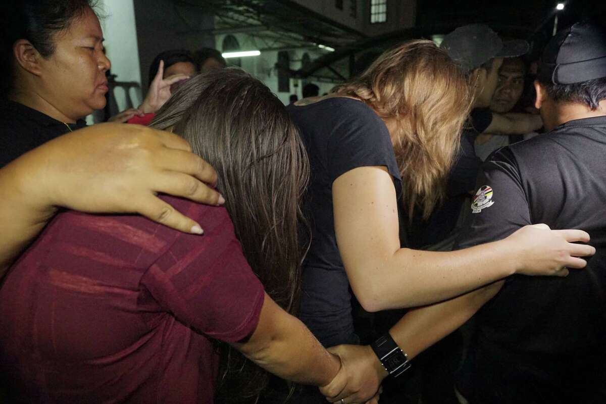 Canadian Danielle Petersen, 22, center right, and left, Eleanor Hawkins, 24, left, of Britain are escorted by police as they leave court in Kota Kinabalu, in eastern Sabah state on Borneo island, Malaysia, on June 12, 2015. Both women were among 10 people who stripped naked and took photos on Mount Kinabalu on May 30.