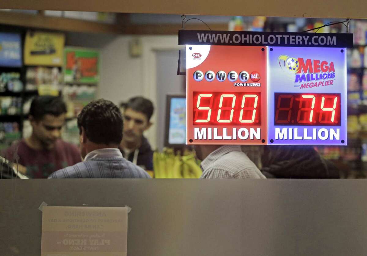 Customers wait to buy lottery tickets at Gateway Newstands in Cleveland Wednesday, Feb. 11, 2015. The Powerball jackpot has climbed to $500 million, making Wednesday night's drawing the fifth largest prize in U.S. history. (AP Photo/Mark Duncan)